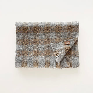 Folded light grey marl and brown cashmere scarf with a textured check design and short fringed ends.