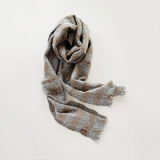 Light grey marl and brown unisex cashmere scarf arranged to show its long drape and textured check pattern.