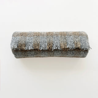 A rolled-up light grey marl and brown cashmere scarf with a textured check design and short fringed ends.