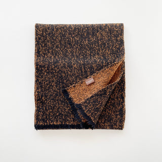 Folded black and warm brown flecked cashmere scarf with short fringed ends.
