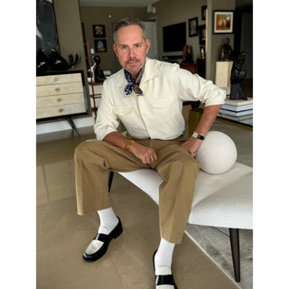 Men’s navy floral and paisley silk neckerchief by LuluLane paired with beige trousers and cream shirt – refined casual look.