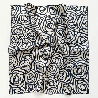 Elegant silk bandana scarf with charcoal grey abstract rose pattern on white background, featuring hand-rolled edges and silky texture
