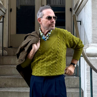 Man wearing retro geometric pattern silk neckerchief scarf with green cable knit sweater – men’s square silk scarf by LuluLane.