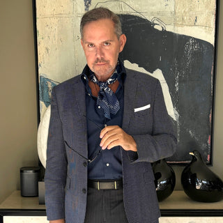 Men’s silk neckerchief styled with a blazer – Blue Kyoto floral print scarf tucked under shirt collar for a refined, layered look.