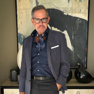 Men’s silk neckerchief styled with a blazer – Blue Kyoto floral print scarf tucked under shirt collar for a refined, layered look.