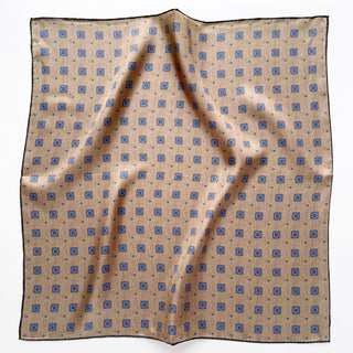 Luxury taupe silk neckerchief with repeating blue geometric medallion pattern, featuring hand-rolled edges and square design for versatile styling.