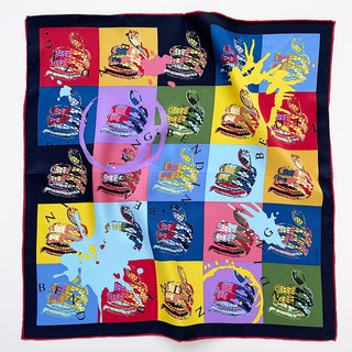 Luxury silk bandana with pop art-style coiled snakes in vibrant colored blocks. Navy border with red trim, featuring colorful snake prints and splatter design.