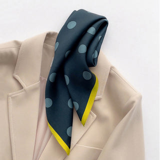 Dark Teal green silk scarf with light blue polka dots and mustard yellow border, styled as a neck accessory on a beige blazer.
