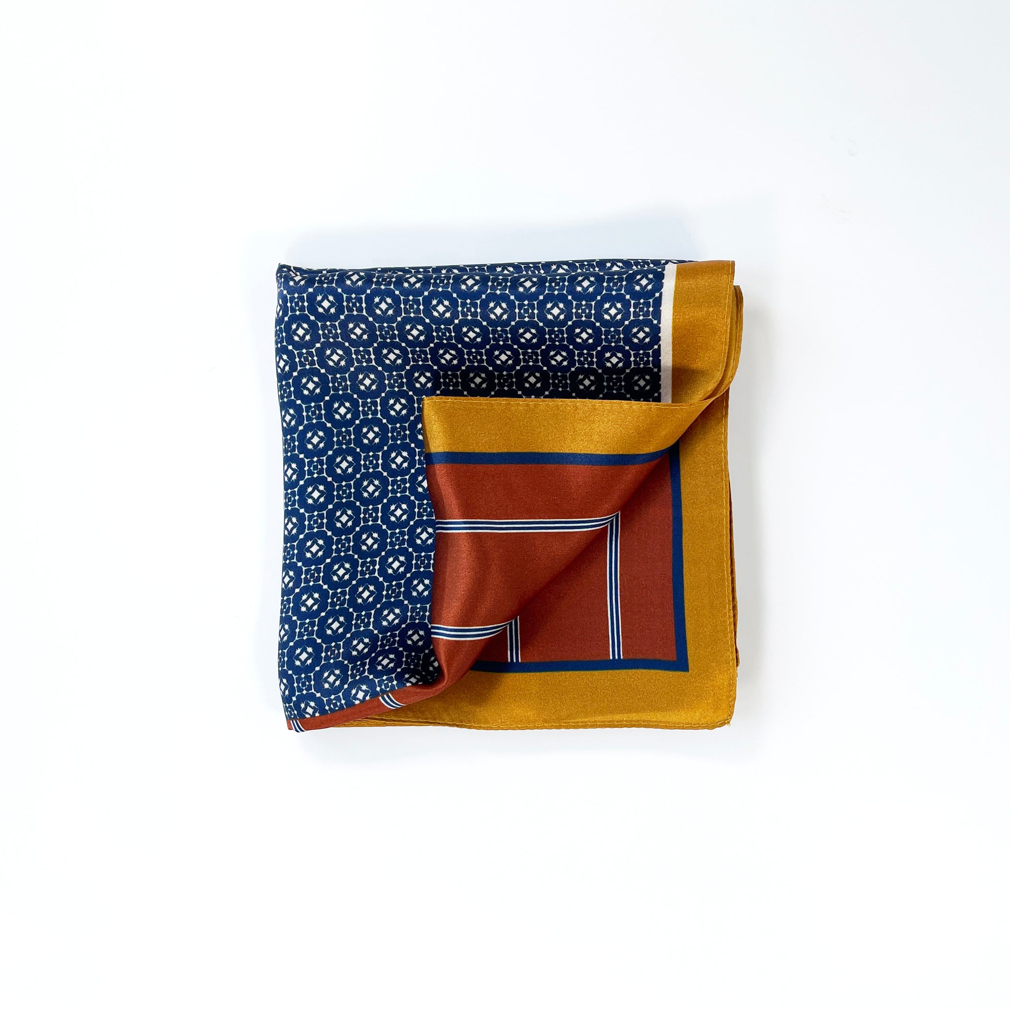 a mens silk scarf with geometric pattern in navy blue, copper and mustard yellow