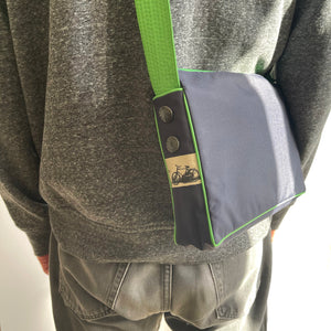 a navy blue crossbody bag with grass green strap