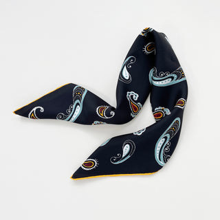 Black silk scarf with decorative paisley pattern in light blue, red, and gold accents, displayed folded with hand-rolled yellow trim visible
