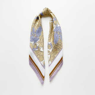 Luxury silk scarf featuring light yellow peonies print on white background with lilac and ochre border, displayed in elegant drape