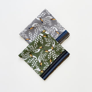 Amazon Toucan organic cotton-silk scarf in stone grey and olive green, folded neatly on a white background.