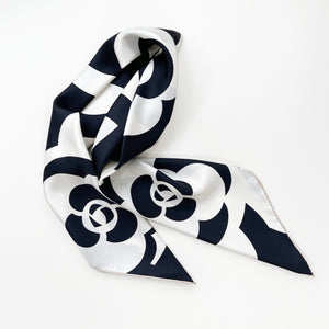 a black and white camellia print large square silk scarf with hand-rolled hems folded as a neck scarf 