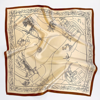 Square pale apricot silk scarf with brown border featuring illustrated city landmarks and decorative floral edges, showcasing luxurious sheen and elegant design
