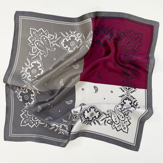 Luxurious plum red and gray silk bandana with intricate paisley pattern, featuring decorative borders and a color-block design on a white background.