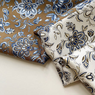 Close-up of mulberry silk men’s neckerchief showing detailed floral patterns in olive brown and cream.