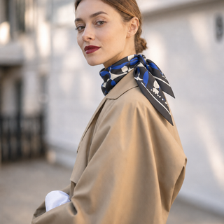 Model wearing the 65cm English Seaside Pebble silk scarf with a classic camel trench coat.