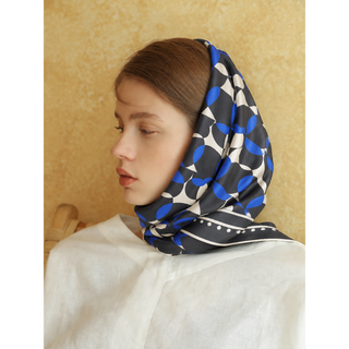 Model wearing the 90cm English Seaside Pebble silk scarf as an elegant headscarf with a white blouse.