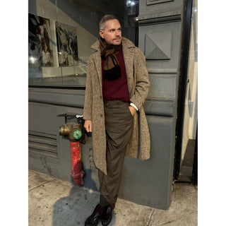 Man wearing a brown and black cashmere scarf by LuluLane in camel coat and burgundy sweater showcasing a sharp and refined look.