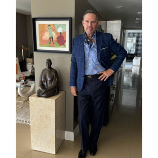 Man wearing a blue Kyoto Bloom silk scarf with a striped shirt and navy check blazer, styled for a sophisticated smart casual look.