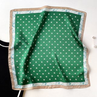 Green silk bandana scarf with white flower pattern, bordered by light blue paisley design and beige trim, displayed flat to show vintage chic style