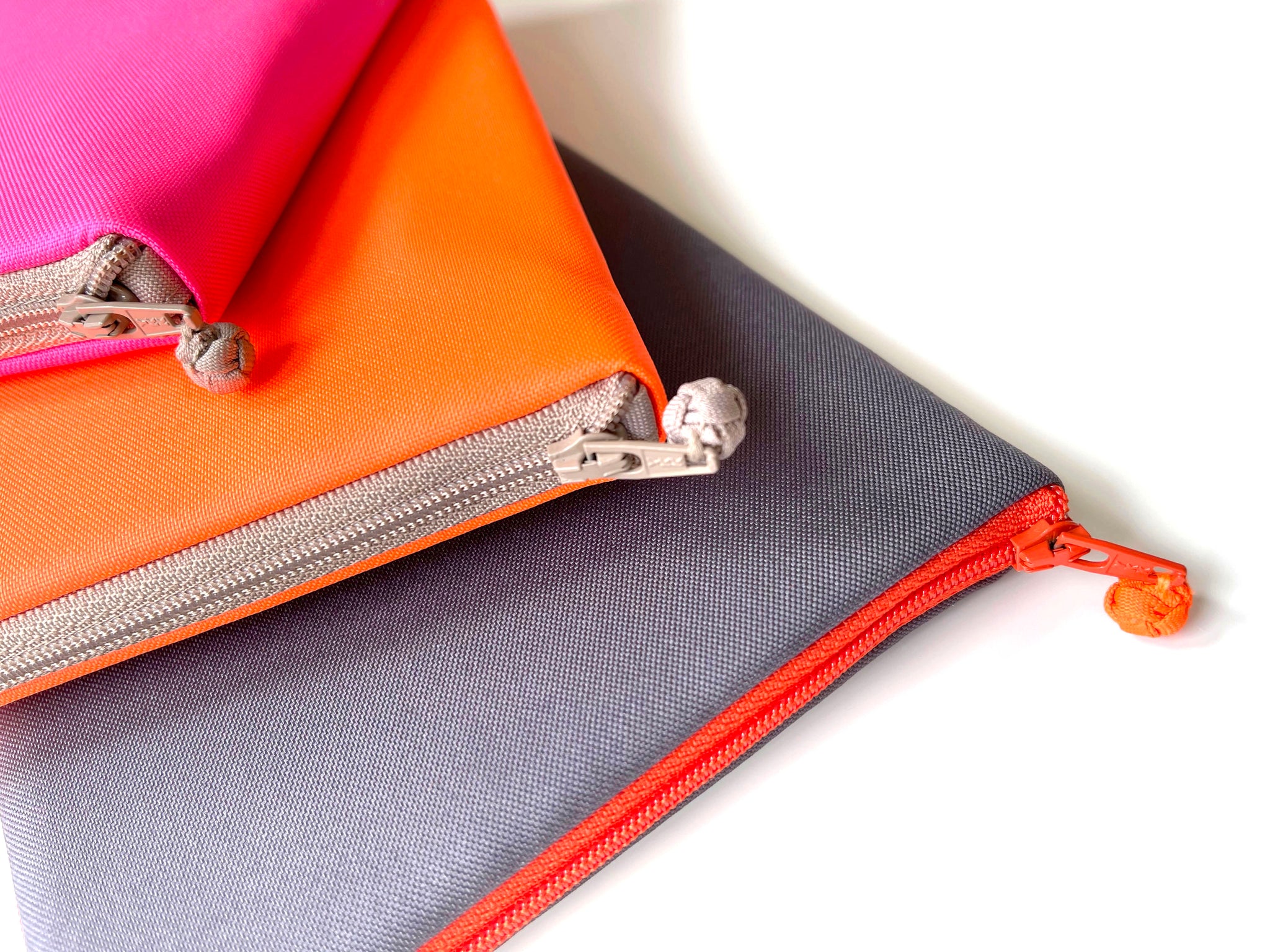 recycled kindle case in three different colors: neon orange, neon pink and dark grey