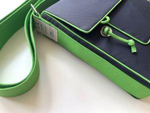 a navy blue preppy style messenger bag with green strap