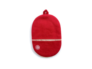 Bright red handmade oven mitt with beige piping detail, decorative embroidered circle pattern, and hanging loop on white background