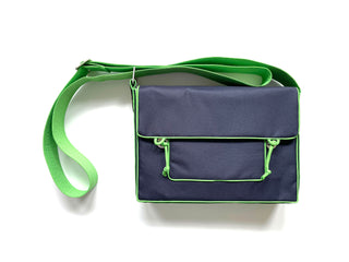 a navy blue preppy style messenger bag with green strap