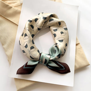 Cream silk bandana with stylish hat pattern, folded and tied with sage green and burgundy border edges, displayed on white paper.