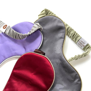 Luxury double-sided silk sleep masks in lavender, gray, and red colors with elegant elastic bands and 100% silk label, showcasing smooth satin texture.