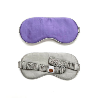 Double-sided luxury silk sleep mask shown in purple and sage green with elastic band, featuring smooth fabric and contoured design for comfort.