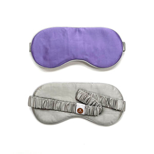 a light purple silk eye mask with grey back side and elastic strap